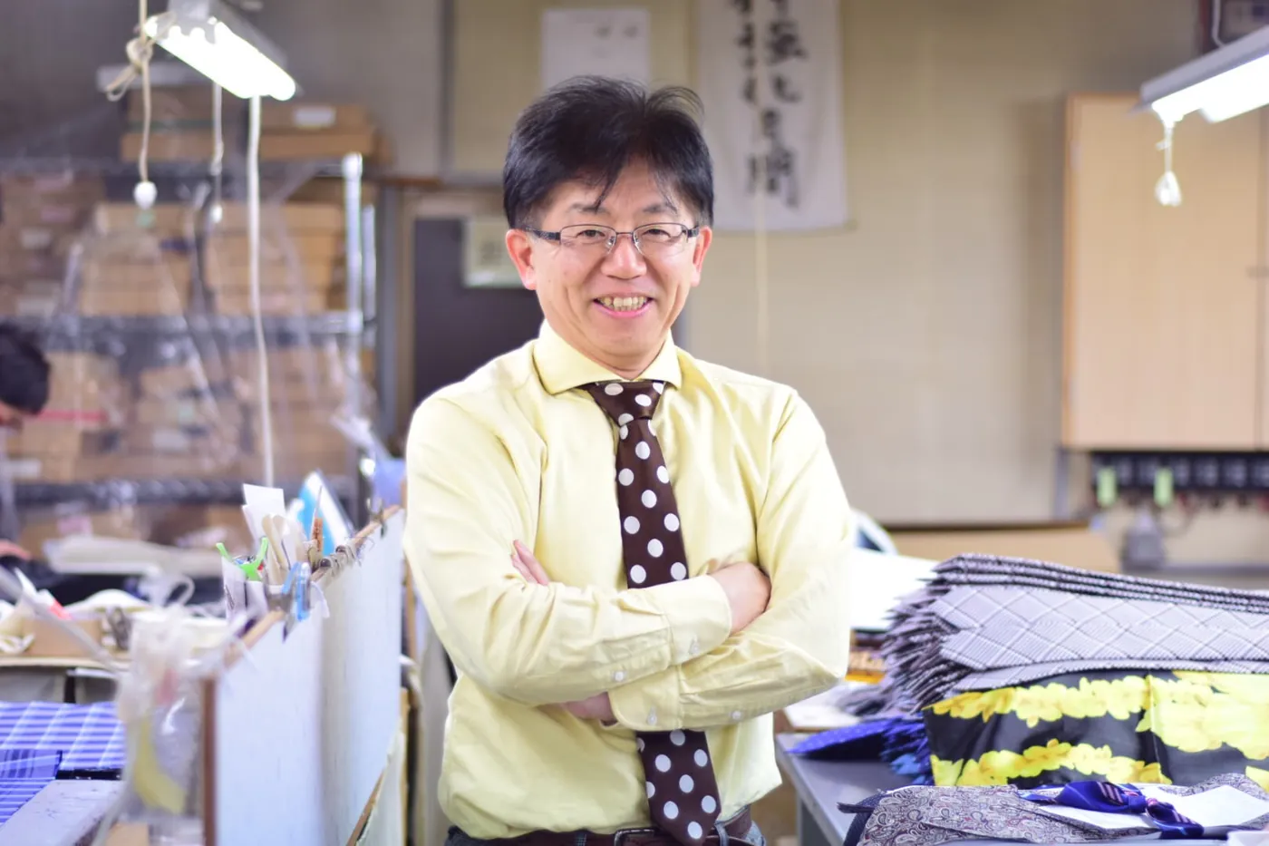 工場で腕を組む代表取締役